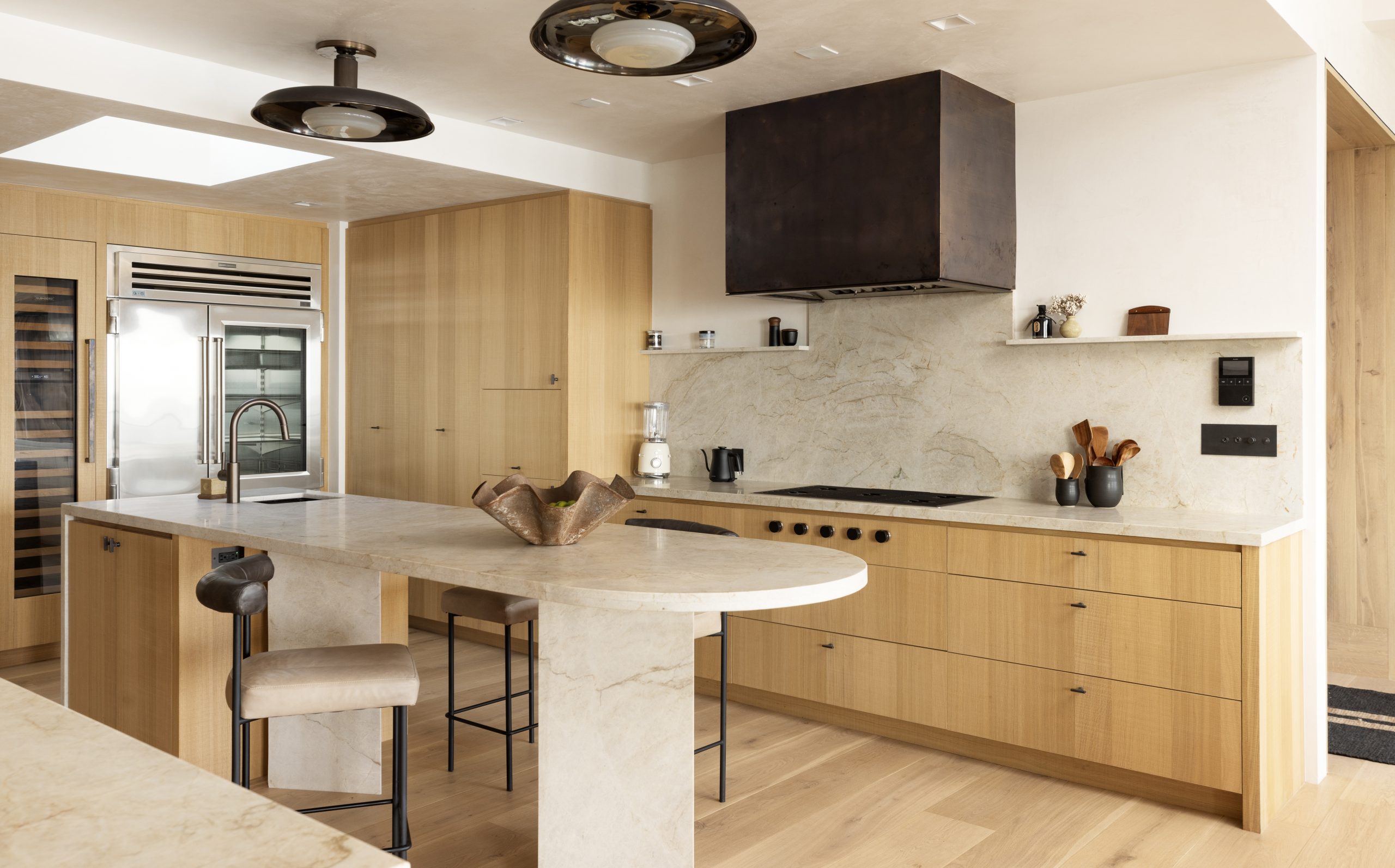 The contemporary kitchen features warm wood and an island with bar seating.