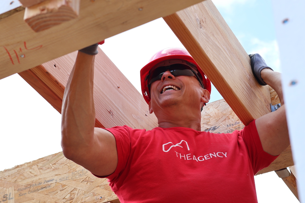 A member of The Agency working to build a home for a local family in need.